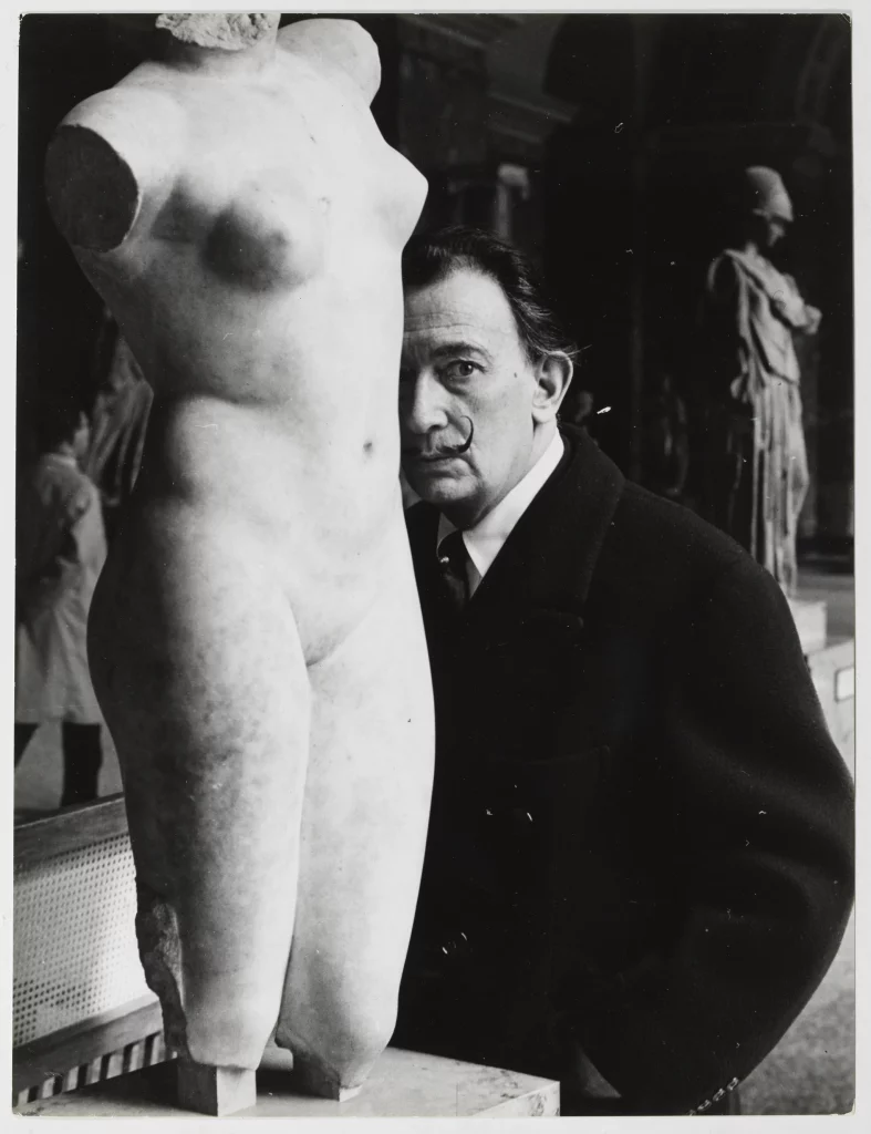 Salvador Dalí visiting the Greek sculpture rooms at the Louvre Museum in Paris, c. 1965 
Atlantic Press. Image rights of Salvador Dalí reserved. Fundació Gala-Salvador Dalí, Figueres, 2024