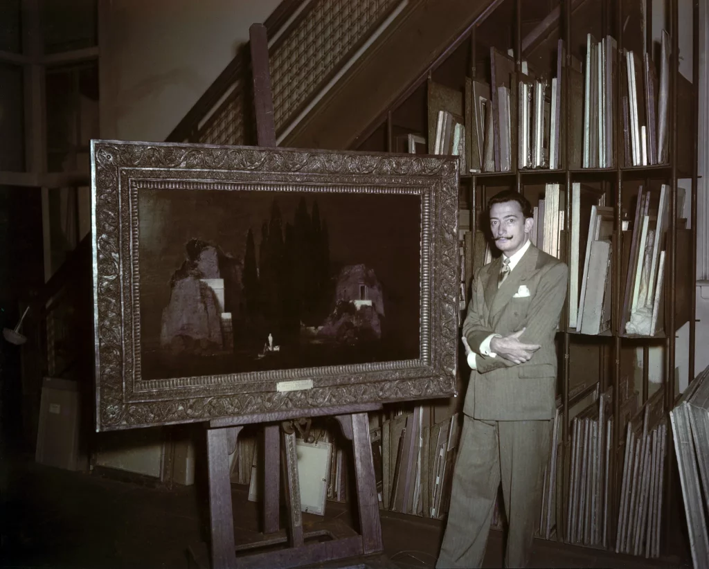 Salvador Dalí junto a la obra <em>La isla de los muertos</em> (1880) de Arnold Böcklin en el almacén del Metropolitan Museum de Nueva York, c. 1948 
Derechos de imagen de Salvador Dalí reservados. FGSD, Figueres, 2024