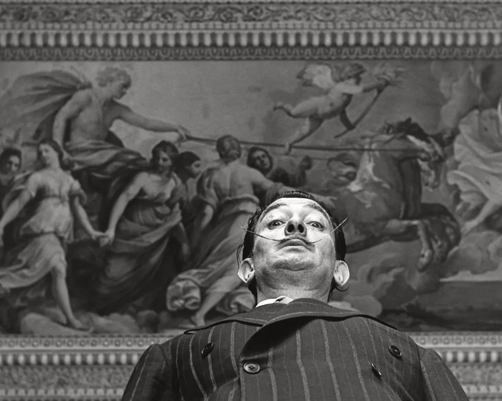 Salvador Dalí bajo el fresco <em>La Aurora</em> (1614) de Guido Reni en el Palazzo Pallavicini Rospigliosi de Roma 
© MAX SCHELER 
Derechos de imagen de Salvador Dalí reservados. FGSD, Figueres, 2024